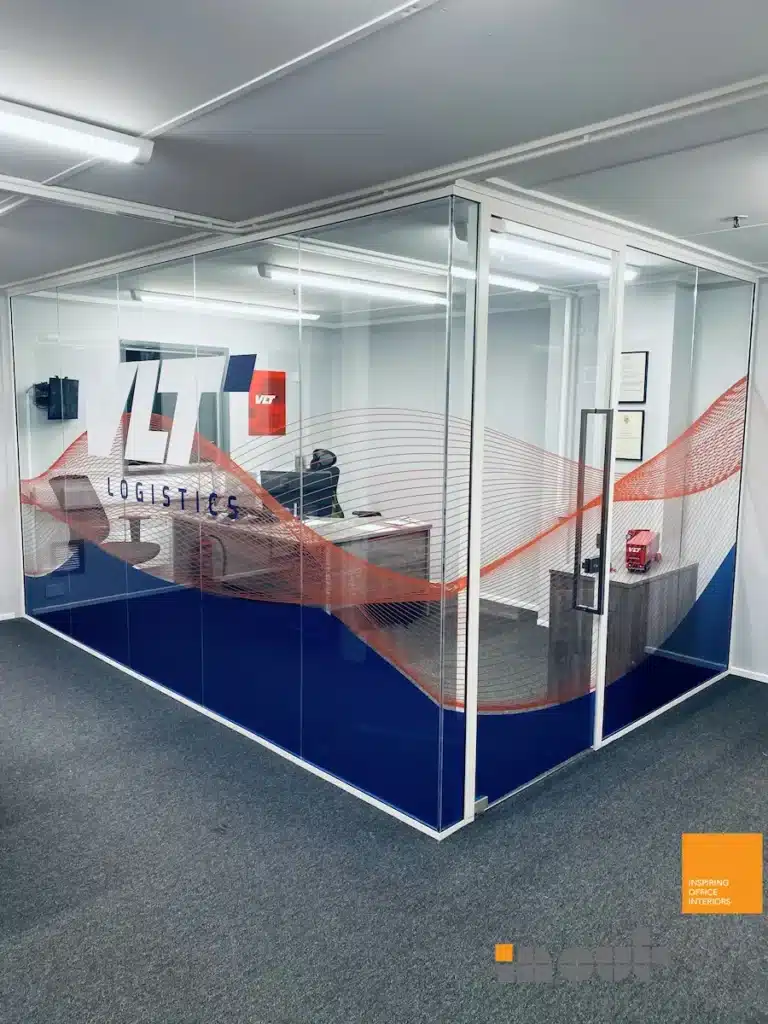 Glass office partition with branded VLT Logistics graphic enclosing a private office