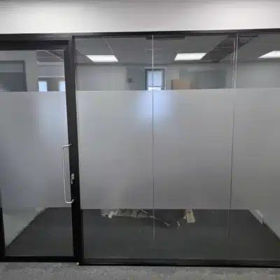 The combination of the 98mm double glazed system, 12.8mm + 10.8mm acoustic laminated glass, double glazed doors, black RAL 9005 frames and frosted manifestation.