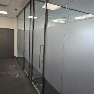 Double glazed partitions with framed glass doors creating 2 rooms.