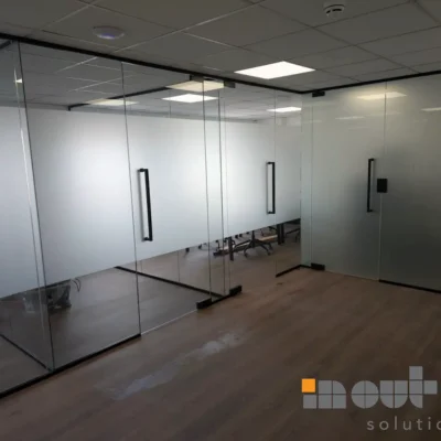 Black-framed glass partition running along an office corridor in Nottingham