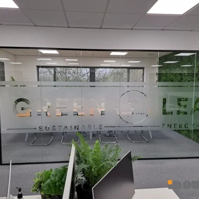 Frosted glass meeting room partition with "Green Leaf Sustainable Energy" branding in Newcastle