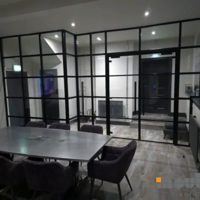 Black-framed glass partition around a corner meeting room in Birmingham office