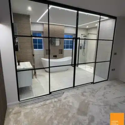 Black-framed glass room divider separating a bedroom from an ensuite bathroom in Hull, Yorkshire