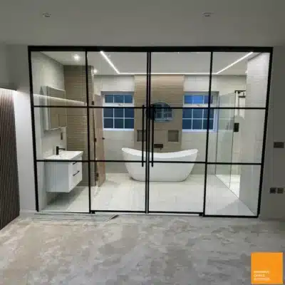 Black-framed interior glass doors opening onto a freestanding bath in Birmingham home
